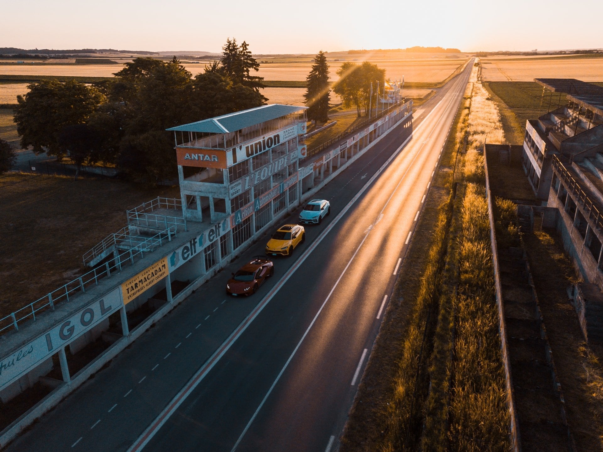 Rennstrecke und vorbeiziehender Verkehr aus der Luft im Abendlicht