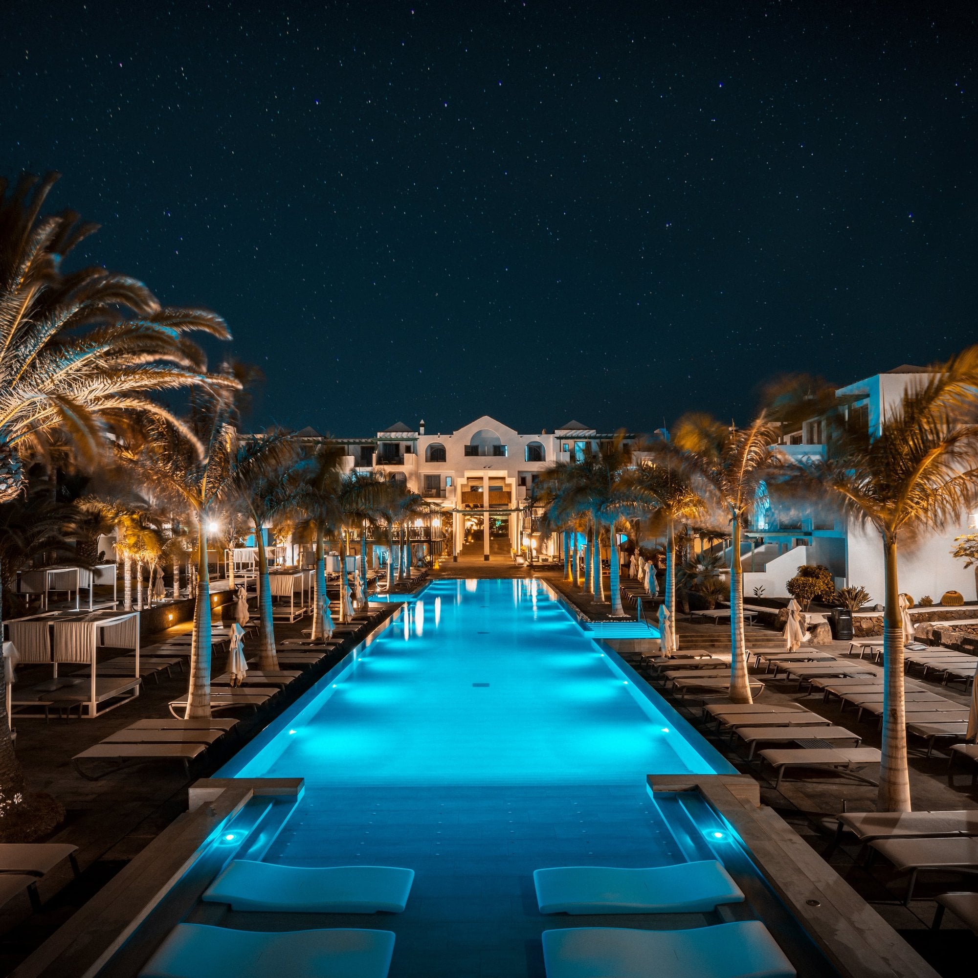 Blau beleuchteter Pool eines Resorts bei Nacht