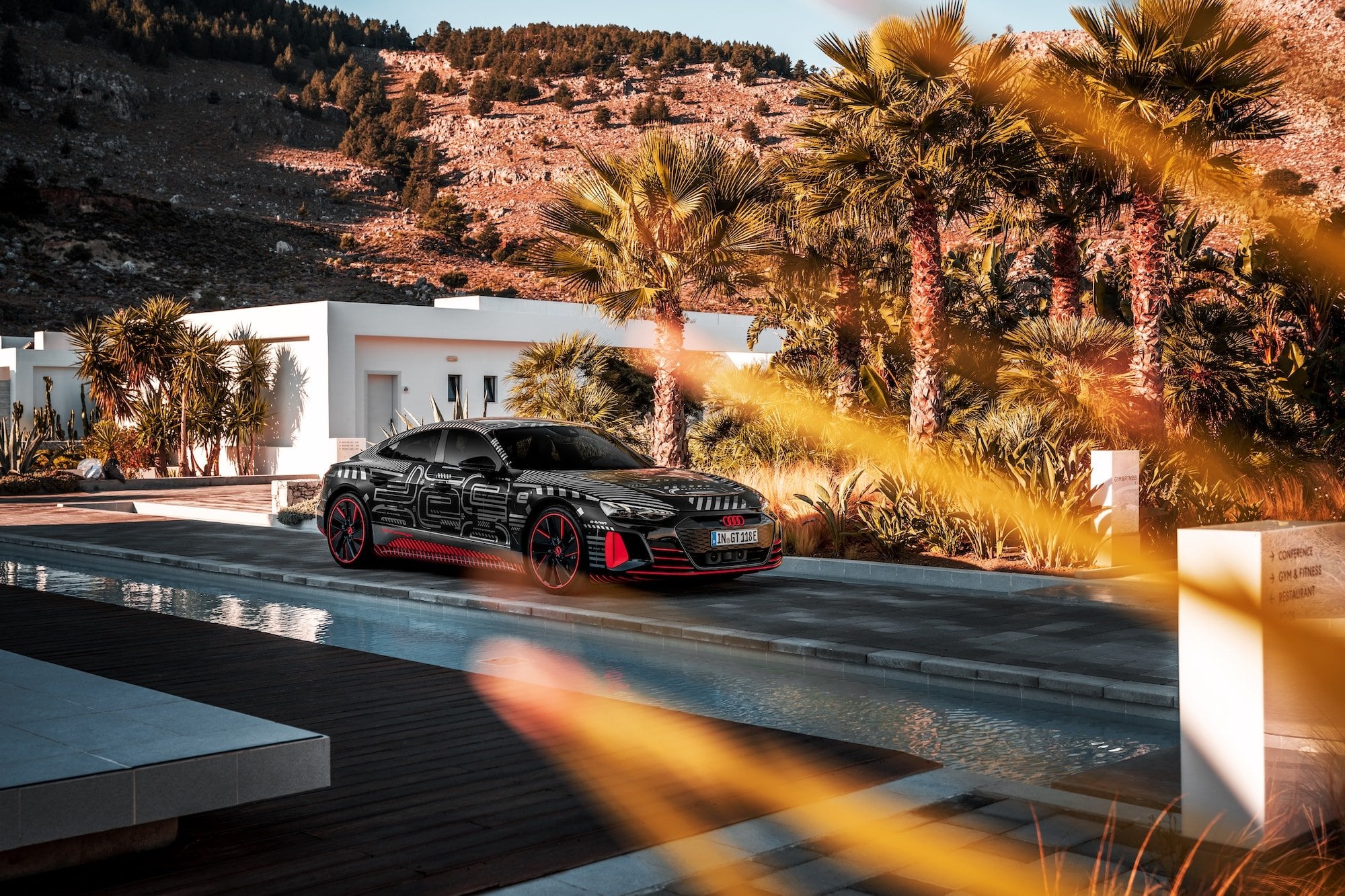 Schwarzer Sportwagen an einer modernen Villa mit Infinity-Pool