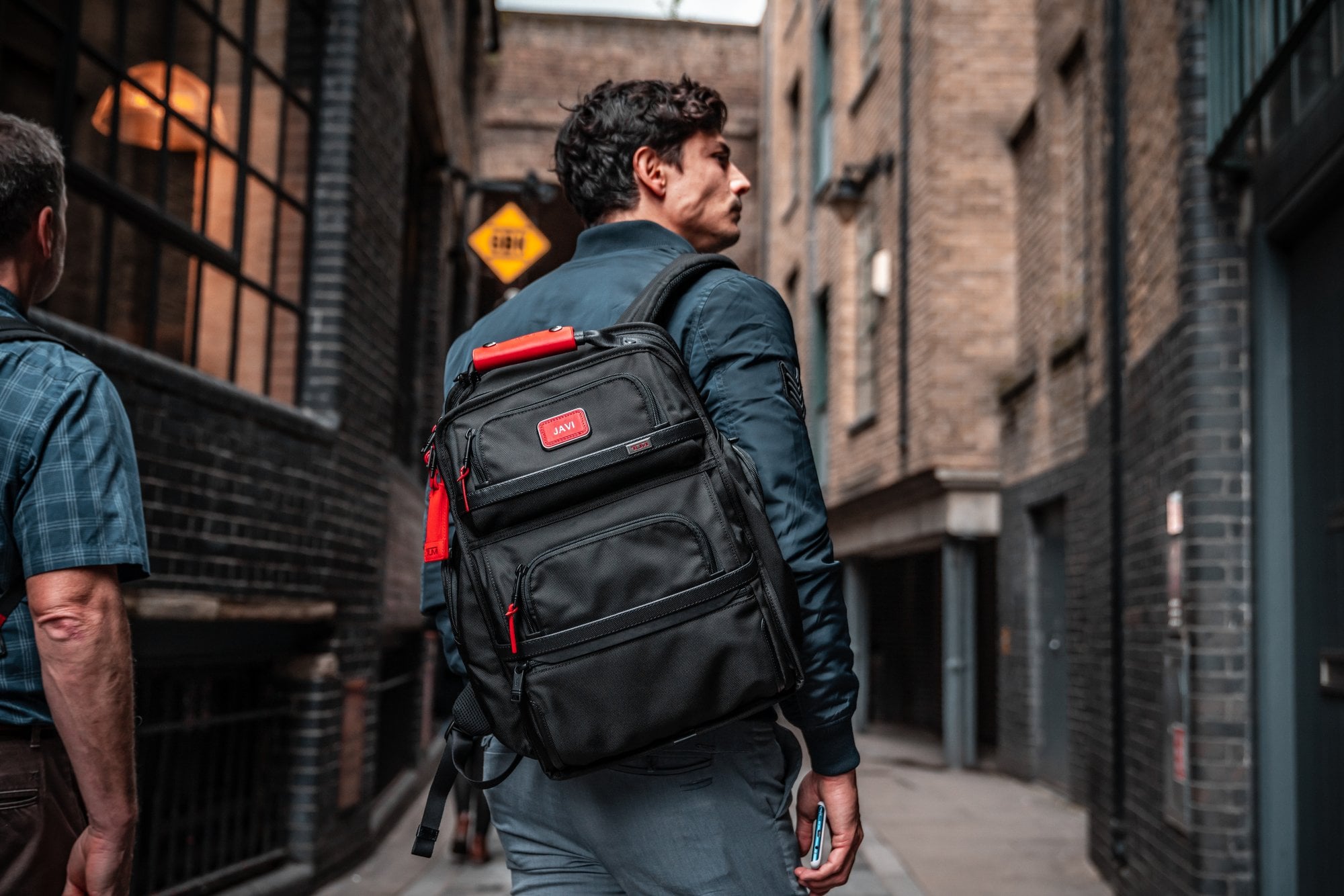 Reisender mit schwarzem Rucksack in einer schmalen Stadtgasse