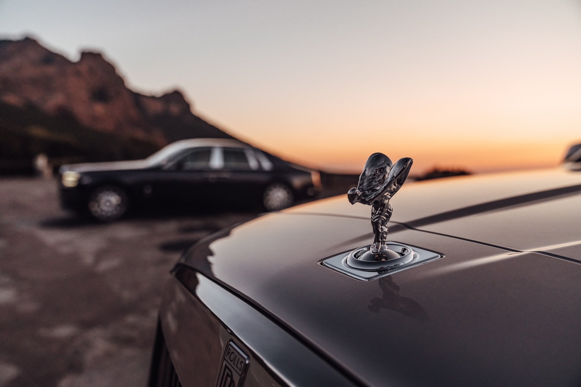 Rolls-Royce-Kühlerfigur vor einem weichen Sonnenuntergang