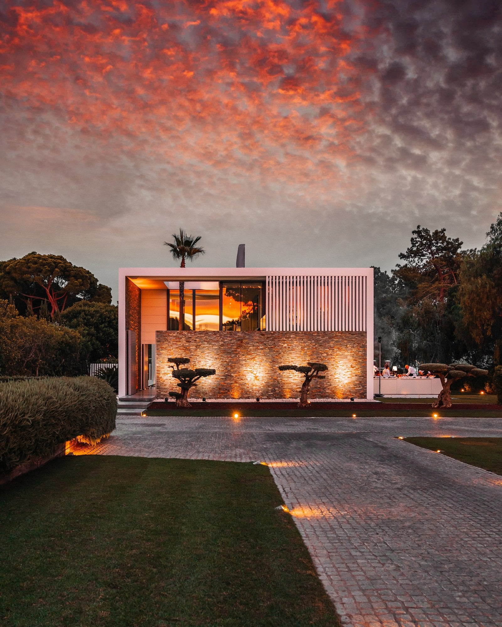 Modernes Haus im warmen Licht unter roten Abendwolken